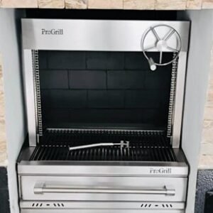 Asador a carbón a medida en acero inoxidable 304 grado alimenticio con elevador alto de volante, parrilla ajustable y acabados premium, fabricado por PROGRILL